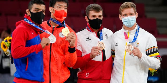 From left, silver medalist Saeid Mollaei of Mongolia, gold medalist Takanori Nagase of Japan, bronze medalists Shamil Borchashvili of Austria and Matthias Casse of Belgium celebrate during the award ceremony for the men -81kg judo match at the Olympics in Tokyo, Japan, Tuesday. (AP Photo/Vincent Thian)