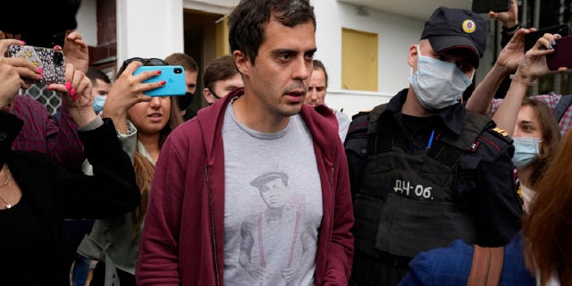 Roman Dobrokhotov, editor-in-chief of The Insider walks, surrounded police and journalists in Moscow, Russia on Wednesday, July 28, 2021.