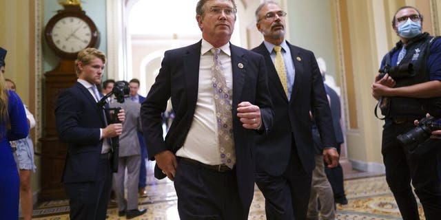 Rep. Thomas Massie, R-Ky., left, Rep. Andy Harris, R-Md., and other conservative members of the House walk to the Senate chamber, as they express their opposition to new mask guidance, at the Capitol in Washington, Thursday, July 29, 2021. Earlier in the day, House Minority Leader Kevin McCarthy, R-Calif., charged that the Centers for Disease Control has become a political arm of the administration. (AP Photo/J. Scott Applewhite)