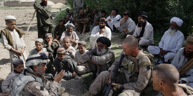 Josh Habib, far left, a 53-year-old translator for the U.S. Marines, speaking with Afghan villagers and two Marines in the Nawa district of Afghanistan's Helmand province.