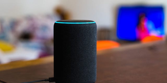 Amazon Alexa smart assistant device connected at home on table, defocused living room in background, no people