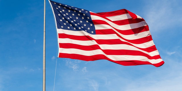 The American flag — flying brightly against a blue sky.  