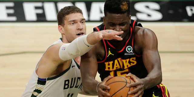 Atlanta Hawks' Clint Capela, right, secures a rebound against Milwaukee Bucks' Brook Lopez, left, during the first half of Game 5 of the NBA Eastern Conference Finals Thursday, July 1, 2021, in Milwaukee. (AP Photo/Aaron Gash)