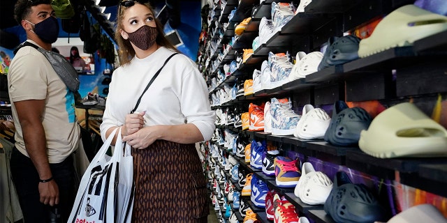 Shoppers wear masks inside of The Cool store Monday, July 19, 2021, in the Fairfax district of Los Angeles. Los Angeles County has reinstated an indoor mask mandate due to rising COVID-19 cases.