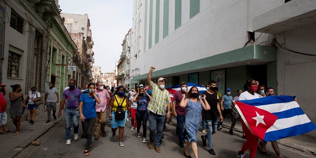 Backers of the government march in Havana, Cuba, Sunday, July 11, 2021. Hundreds of supporters of the government took to the streets while hundreds  protested against ongoing food shortages and high prices of foodstuffs. (AP Photo/Ismael Francisco)