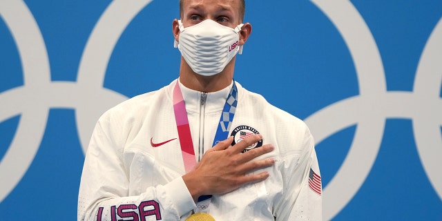 Caeleb Dressel of the United States stands on the podium after receiving his gold medal for the men's 100-meter freestyle at the 2020 Summer Olympics, Thursday, July 29, 2021, in Tokyo. (Associated Press)