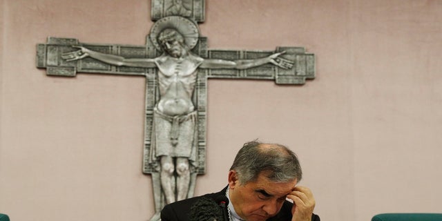 FILE - In this Friday, Sept. 25, 2020 file photo, Cardinal Angelo Becciu looks down as he meets the media during a press conference in Rome. (AP Photo/Gregorio Borgia, File)