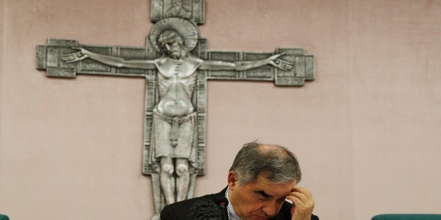 FILE - In this Friday, Sept. 25, 2020 file photo, Cardinal Angelo Becciu looks down as he meets the media during a press conference in Rome. (AP Photo/Gregorio Borgia, File)