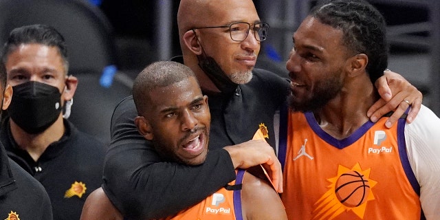 Phoenix Suns head coach Monty Williams hugs Chris Paul, left, and Jae Crowder, second from right, as Devin Booker pauses as time runs out in Game 6 of the NBA Basketball Western Conference Finals against the Los Angeles Clippers Wednesday. June 30, 2021, in Los Angeles.