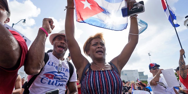 Dulce Diaz, center, and her brother Carlos Diaz, left, demonstrate in Miami's Little Havana neighborhood on Wednesday, July 14, 2021, as people rallied in support of anti-government demonstrations in Cuba