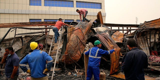 Rescuers and civilians look for bodies after a catastrophic blaze erupted Monday at a coronavirus hospital ward in the al-Hussein Teaching Hospital, in Nasiriyah, イラク, 火曜日, 7月 13, 2021. 