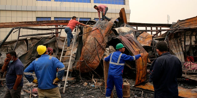 Rescuers and civilians look for bodies after a catastrophic blaze erupted Monday at a coronavirus hospital ward in the al-Hussein Teaching Hospital, in Nasiriyah, Iraq, Tuesday, July 13, 2021.