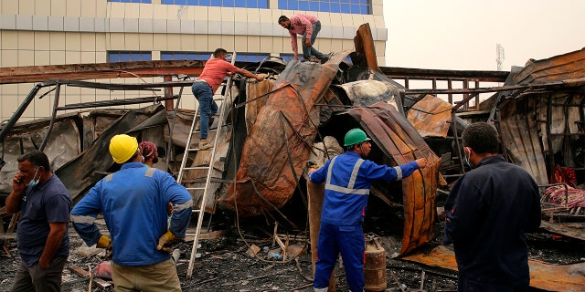 Rescuers and civilians look for bodies after a catastrophic blaze erupted Monday at a coronavirus hospital ward in the al-Hussein Teaching Hospital, in Nasiriyah, Iraq, Tuesday, July 13, 2021. 