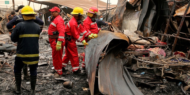 Rescuers look for bodies after a catastrophic blaze erupted Monday at a coronavirus hospital ward in the al-Hussein Teaching Hospital, in Nasiriyah, Iraq, Tuesday, July 13, 2021.