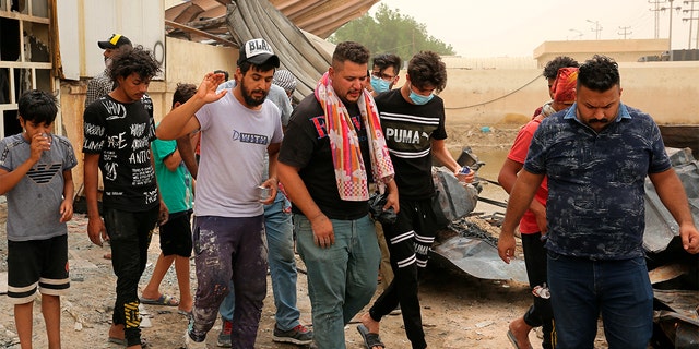 Rescuers and civilians look for bodies after a catastrophic blaze erupted Monday at a coronavirus hospital ward in the al-Hussein Teaching Hospital, in Nasiriyah, イラク, 火曜日, 7月 13, 2021. 
