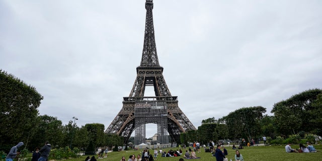 People relax at the Champ de Mars garden next to the Eiffel Tower in Paris, July 16, 2021.