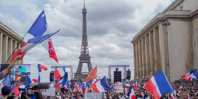 Des milliers de manifestants se rassemblent place Trocadéro près de la tour Eiffel pour assister à une manifestation à Paris, France, samedi 24 juillet 2021, contre le pass COVID-19 qui accorde aux personnes vaccinées une plus grande facilité d'accès aux lieux.
