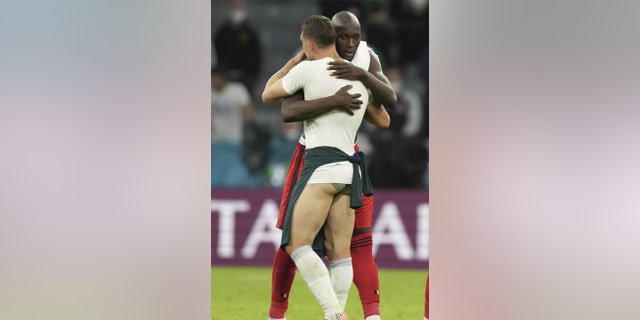 Italy's Andrea Belotti, left, and Belgium's Romelu Lukaku hug after the Euro 2020 soccer championship quarterfinal match between Belgium and Italy at the Allianz Arena stadium in Munich, Germany, Friday, July 2, 2021. (AP Photo/Matthias Schrader, Pool)