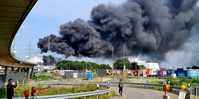 A dark cloud of smoke rises above the chemical park in Leverkusen, Germany on Tuesday, July 27, 2021. Firefighters from the site fire department are on duty. (Mirko Wolf / dpa via AP)