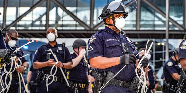Police officers stand guard during a protest following the death of George Floyd outside of the CNN Center next to Centennial Olympic Park in downtown Atlanta, Georgia, on May 29, 2020.