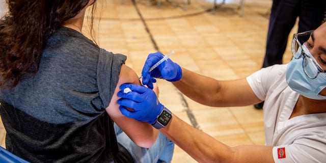 Un trabajador de la salud administra una vacuna Covid-19 a un adolescente en un sitio de vacunación en una iglesia en Long Beach, Nueva York, el jueves 13 de mayo de 2021.