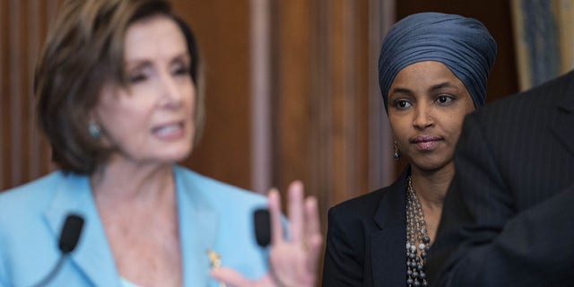 Representative Ilhan Omar, a Democrat from Minnesota, listens as U.S. House Speaker Nancy Pelosi, a Democrat from California, left, speaks during a bill enrollment ceremony for the Juneteenth National Independence Day Act at the U.S. Capitol in Washington, D.C., U.S., on Thursday, June 17, 2021. The legislation, passed by the House and Senate earlier this week, would make June 19 a federal holiday commemorating the end of slavery in the U.S. Photographer: Sarah Silbiger/Bloomberg via Getty Images