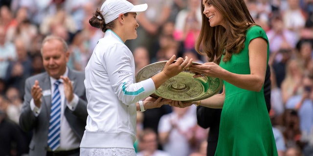 Australia's Ashleigh Barty receives the trophy from Britain's Catherine, Duchess of Cambridge, after defeating Czech Karolina Pliskova in their women's singles final match on day 12 of the 2021 Wimbledon Championships at the All England Tennis Club in Wimbledon, in South West London, July 10, 2021. (Photo by AELTC / BEN SOLOMON / POOL / AFP via Getty Images)