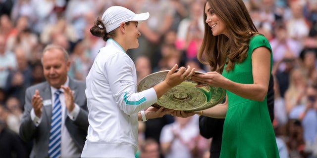 Australia's Ashleigh Barty receives the trophy from Britain's Catherine, Duchess of Cambridge, after defeating Czech Karolina Pliskova in their women's singles final match on day 12 of the 2021 Wimbledon Championships at the All England Tennis Club in Wimbledon, in South West London, July 10, 2021. (Photo by AELTC / BEN SOLOMON / POOL / AFP via Getty Images)