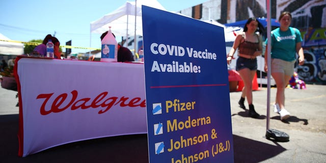 A sign displays the types of COVID-19 vaccination doses available at a Walgreens mobile bus clinic on June 25, 2021 in Los Angeles, California. City employees have until Dec. 18 to comply with a vaccina requirment under a plan passed by lawmakers Tuesday. 
