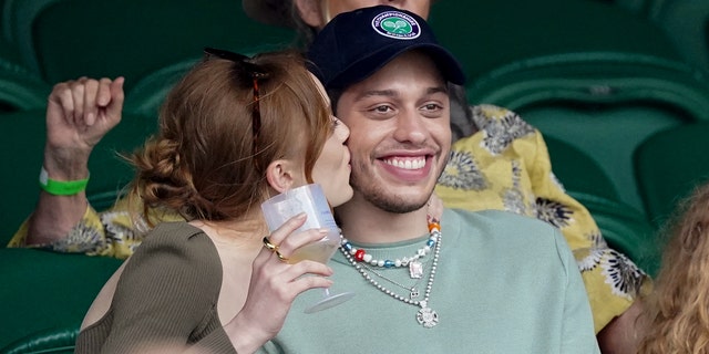 Phoebe Dynevor and Pete Davidson exchange sweet gestures on day 6 of the Wimbledon Tennis Championships at the All England Lawn Tennis and Croquet Club on July 03, 2021 in London. (Photo by Karwai Tang/WireImage)