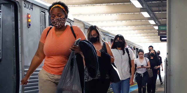 Commuters, most of whom can be seen wearing face masks, travel on the L train system in the Loop on July 27, 2021, in Chicago, Illinois. 