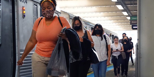 Commuters, most of whom can be seen wearing face masks, travel on the L train system in the Loop on July 27, 2021, in Chicago, Illinois.