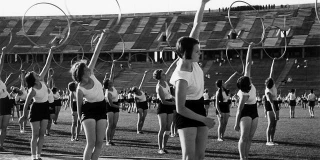 Women entered the Olympic gymnastics space during the Berlin 1936 Summer Olympics. This file photo shows gymnasts performing at the Olympic Stadium with rings.