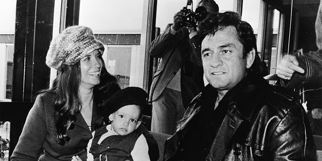 American country singer Johnny Cash (1932 - 2003) sits inside an airport with his wife June Carter Cash (1929 - 2003) and their infant son John Carter Cash, as the singer arrived in Copenhagen, Denmark to begin his Scandinavian tour, circa 1971.