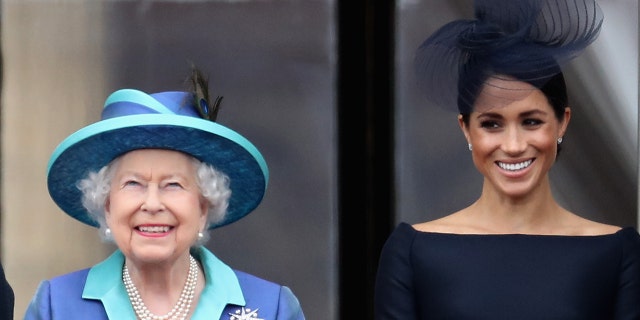 Queen Elizabeth II and Meghan, Duchess of Sussex watch the RAF flypast on the balcony of Buckingham Palace, as members of the Royal Family attend events to mark the centenary of the RAF on July 10, 2018 in London, England.  