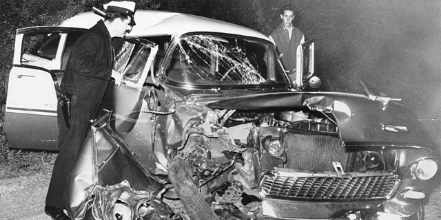 A policeman examines the wreckage of actor Montgomery Clift's car after it crashed into a power pole following a dinner party at the home of Michael Wilding and Elizabeth Taylor. Clift suffered serious head injuries.
