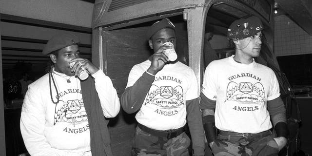 Three unidentified guardian angels pose for a photo on November 7, 1987 at an event where guardian angels present radio personality Howard Stern with an award thanking him for his support at Boerum Place subway station in New York, New York.