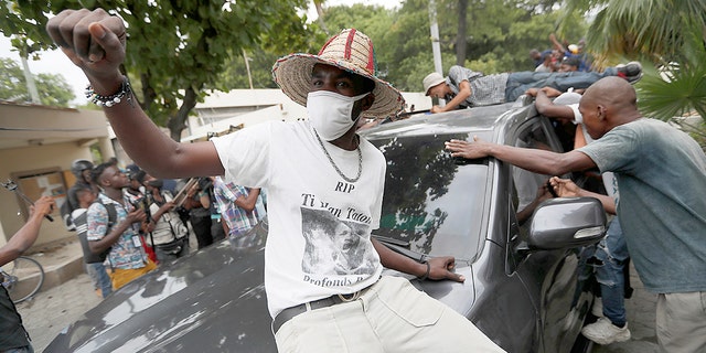 Supporters of former Senator Steven Benoit shout outside the courthouse as he leaves after being summoned for questioning in Port-au-Prince on Monday, July 12, 2021. Prosecutors have called for top politicians plan as Benoit meet with officials for questioning in connection with the investigation into the assassination of President Jovenel Moise.  (AP Photo / Fernando Llano)