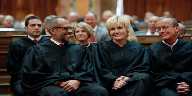 In this Jan. 14, 2020 photo, Iowa Supreme Court Justices Christopher McDonald, left, Susan Christensen, center, and Edward Mansfield, right, attend Iowa Gov. Kim Reynolds' Condition of the State address at the Statehouse in Des Moines, Iowa. (AP)