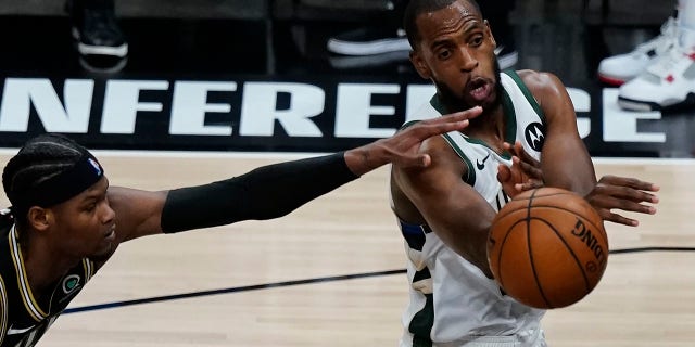 Milwaukee Bucks forward Khris Middleton, right, passes the ball as Atlanta Hawks forward Cam Reddish, left, defends during the second half in Game 6 of the Eastern Conference finals in the NBA basketball playoffs Saturday, July 3, 2021, in Atlanta. (AP Photo/John Bazemore)