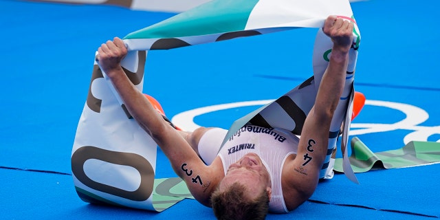 Kristian Blummenfelt of Norway celebrates aafter crossing the finish line to win the gold medal during the men's individual triathlon at the 2020 Summer Olympics, Monday, July 26, 2021, in Tokyo, Japan. (AP Photo/Jae C. Hong)