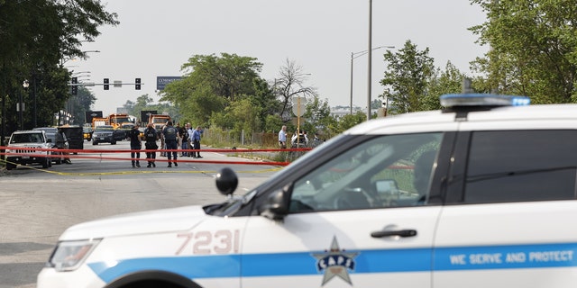 Law enforcement officers investigate a crime scene near the border between the Morgan Park and West Pullman neighborhoods on July 7, 2021 in Chicago, Illinois.
