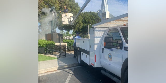 Long Beach city crews clean a statue of Martin Luther King Jr., after it was found vandalized. 