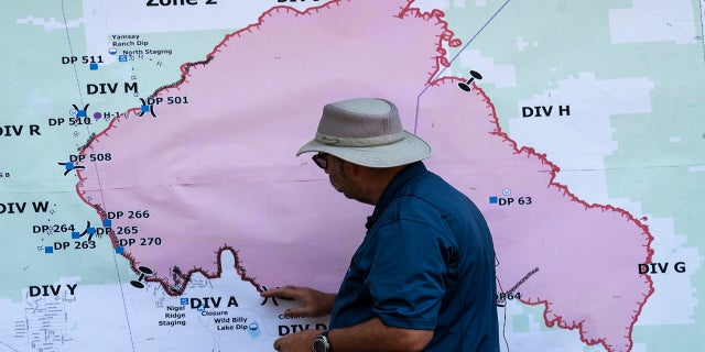 Operations Section Chief Bert Thayer examines a map of the Bootleg Fire, Tuesday, July 13, 2021, in Chiloquin, Ore. (AP Photo)