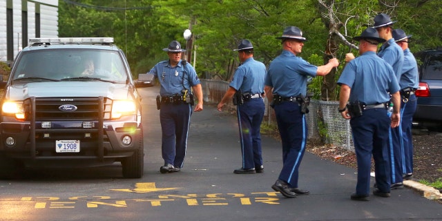 State Police troopers await the arrival of suspects outside a district court office. Pennsylvania lawmakers this week approved a bill that criminalizes fleeing authorities on foot.