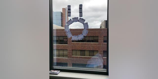 Liz Mixdorf and her husband first made a face on their son Meyer Mixdorf's window out of sticky notes at Children's Mercy Kansas City in Missouri to lift his spirits after a stem cell transplant. They ended up receiving a response from Johnna Schindlbeck, a Truman Medical Centers?employee who works across the street, in May 2021.