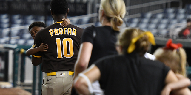 Jurickson Profar of the San Diego Padres is seen comforting a child after Saturday's Nationals-Padres game was suspended following gunfire outside the stadium. (Getty Images)