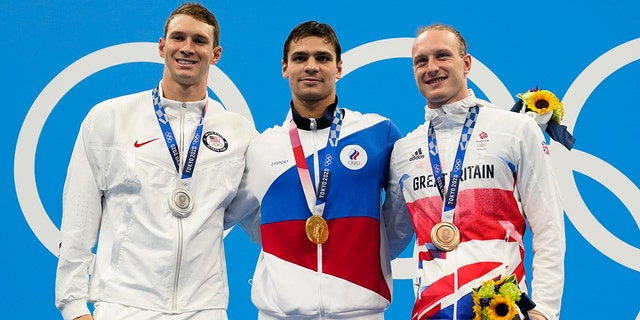 From left, Ryan Murphy, of United States, Evgeny Rylov, of Russian Olympic Committee, and Luke Greenbank, of Britain, pose with their medals after the men's 200-meter backstroke final at the 2020 Summer Olympics, Friday, July 30, 2021, in Tokyo, Japan. (AP Photo/Gregory Bull)