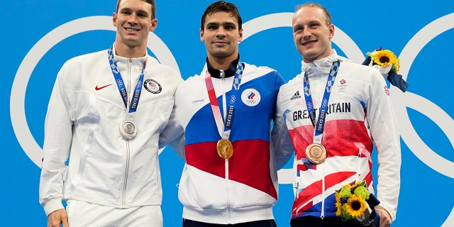 From left, Ryan Murphy, of United States, Evgeny Rylov, of Russian Olympic Committee, and Luke Greenbank, of Britain, pose with their medals after the men's 200-meter backstroke final at the 2020 Summer Olympics, Friday, July 30, 2021, in Tokyo, Japan. (AP Photo/Gregory Bull)