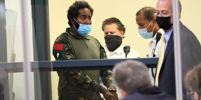 Quinn Cumberlander, left, one of 11 people charged in connection with an armed standoff along a Massachusetts highway last weekend, appears during his arraignment at Malden District Court, Tuesday, July 6, 2021, in Medford, Mass. (Suzanne Kreiter/The Boston Globe via AP, Pool)